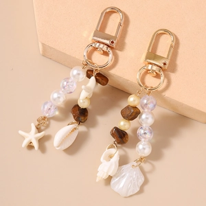 Close-up of ocean-themed beaded keychain with starfish and seashell charms in gold finish