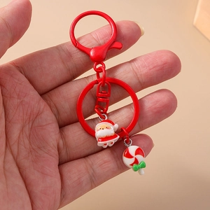 Christmas Santa Claus keychain with red candy pendant and metal lobster clasp held in hand
