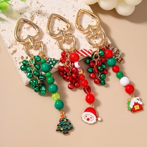 Three festive Christmas keychains with Santa, tree, and bells on heart-shaped hooks