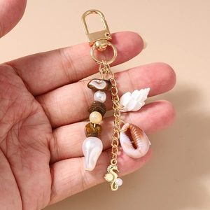 Detailed view of ocean-themed keychain with starfish, seashell and golden seahorse charm