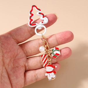 Gros plan du porte-clés bonhomme de neige de Noël avec breloques colorées sur fond rose