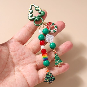 Détail d'un porte-clés de Noël avec perles festives et pendentifs en émail à la main