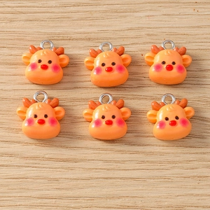 Detail of six cute orange reindeer resin charms with metal loops on wood background