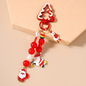 Gros plan d'un porte-clés de Noël avec perles rouges et breloques de Père Noël et bonhomme
