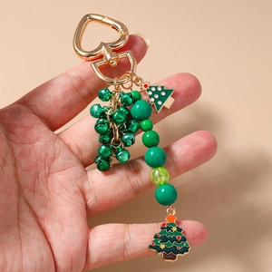 Detailed close-up of a Christmas tree keychain with green beads and golden heart clasp