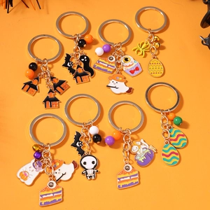 Halloween keychain set with ghost, bat and skull charms on orange background