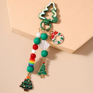 Détails d'un porte-clés de Noël avec sapin émaillé, couronne et perles colorées