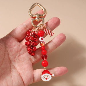 Detail of Christmas keychain with Santa charm, red bells, and candy cane hanging