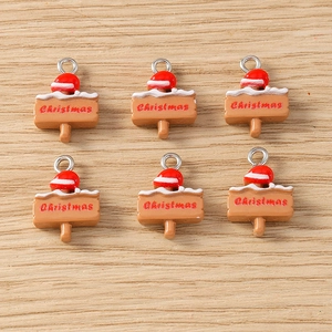 Macro detail of resin Christmas sign pendants with red hats and silver metal loops