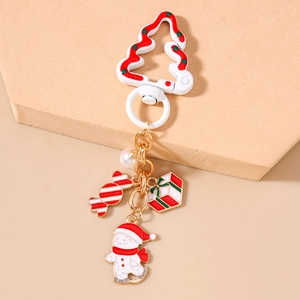 Vue détaillée d'un porte-clés de Noël avec bonhomme de neige en émail et breloque cadeau