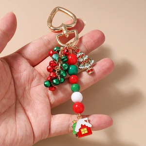 Detail of Christmas keychain featuring festive bells, beads, and a green tree charm