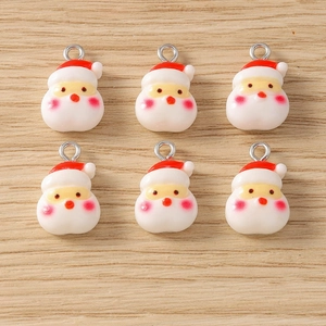 Detail of 6 resin Santa Claus charms with silver metal loops on a wooden background