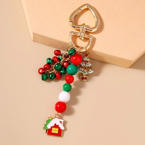 Detail of Christmas keychain with colorful bells and enamel tree charms on stone base