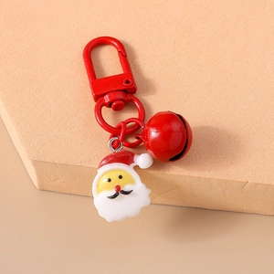 Detail of a Christmas keychain featuring a red Santa Claus pendant and a matching round bell