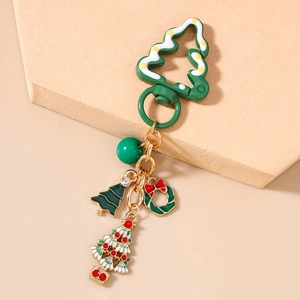 Vue détaillée d'un porte-clés sapin de Noël vert avec breloques colorées et alliage doré