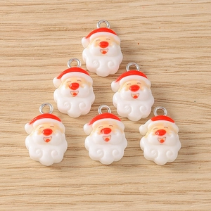 Close-up of six resin Santa Claus charms with silver rings for DIY Christmas jewelry