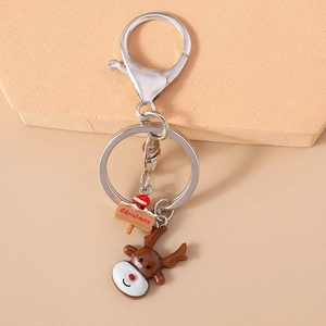 Close-up of Christmas keychain with elk pendant and lobster clasp on textured surface