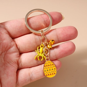 Detailed close-up of Halloween keychain with yellow spider and enamel egg pendant charms