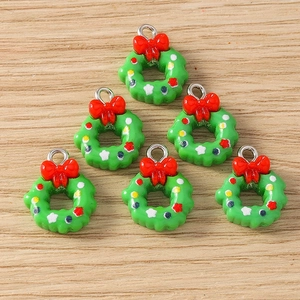 Detailed view of six Christmas wreath charms with red bows for DIY jewelry making