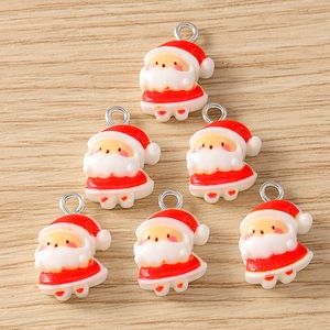 Detailed close-up of six resin Santa Claus charms with silver metal rings for DIY jewelry