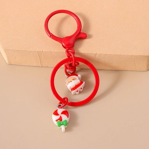 Detail of red Christmas keychain with Santa Claus and candy cane resin pendants