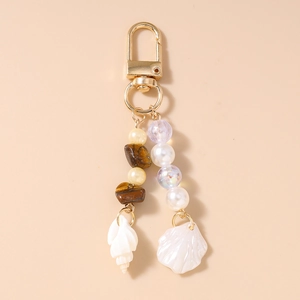 Detailed macro view of ocean-themed keychain with seashell, conch and pearlescent beads