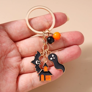 Detail of Halloween keychain featuring bat, ghost, and haunted house enamel charms
