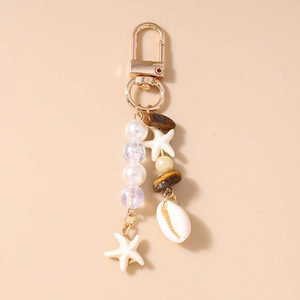 Detail of starfish and shell keychain with pearls and beads on a gold-tone lobster clasp
