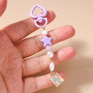 Dettaglio di un portachiavi con perle viola, stelle e ciondolo metallico geometrico