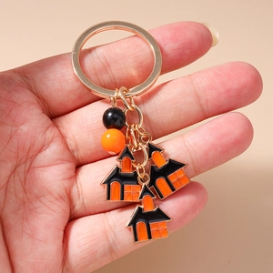 Detailed close-up of a Halloween keychain with golden ring and enamel castle charms