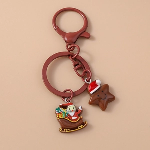 Detail of Christmas keychain with Santa on sleigh and star charms in red metal finish