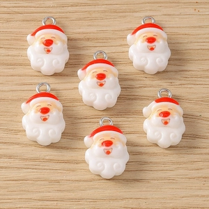 Detailed view of six resin Santa Claus charms with silver metal rings for DIY jewelry making