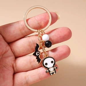 Close-up of Halloween keychain featuring bat pendant and skull charm with beads