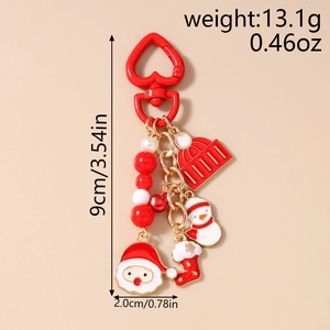 Detail of Christmas keychain with Santa, snowman and red beaded charms on plain background