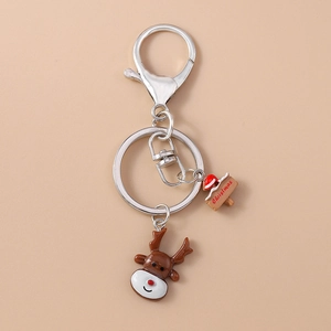 Close-up of a Christmas reindeer keychain with silver metal clasp and a wooden sign pendant