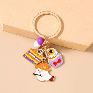 Detail of Halloween enamel keychains with ghost, cake, and eyeball charms on gold ring