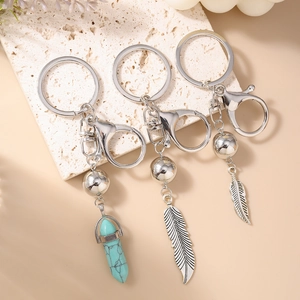 Porte-clés bohème argenté avec prisme hexagonal turquoise et pendentifs plumes en métal
