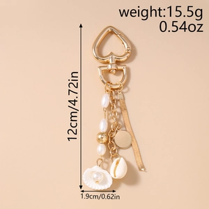 Detail of ocean-themed keychain with pearls, white shell, and heart spring clasp