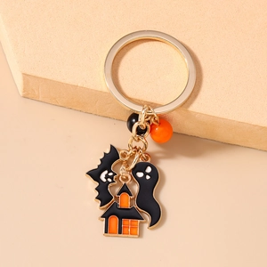Detail of Halloween keychain featuring bat, ghost, and castle charms with orange beads