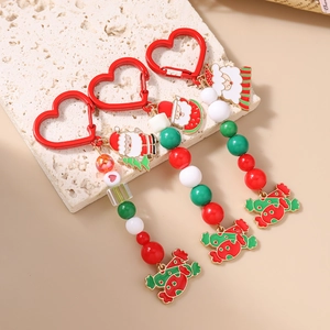 Christmas beaded keychains with Santa Claus and candy cane pendants on stone background