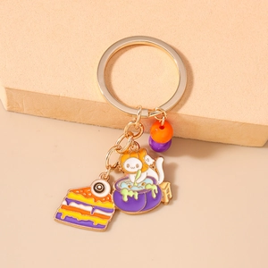 Close-up of Halloween keychain featuring an enamel eye cake and cat with pumpkin hat