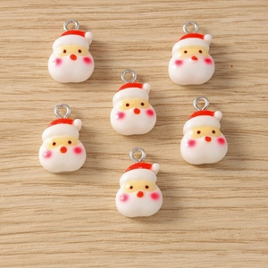 Detailed macro view of 6 mini Santa Claus resin charms with silver rings for DIY jewelry making