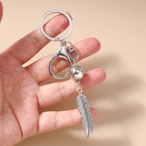 Gros plan du pendentif plume en argent vintage sur un porte-clés bohème en turquoise