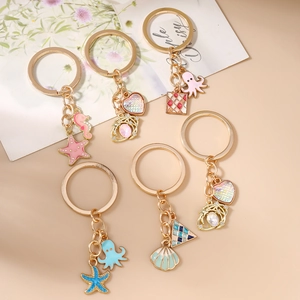 Set of 6 gold marine keychains featuring seahorse starfish and shell enamel charms