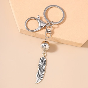 Détail d'un pendentif en plume argentée aux textures fines avec fermoir mousqueton