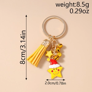 Detail view of gold Christmas keychain with yellow tassel and star charm with Santa hat