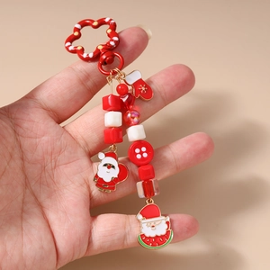 Detailed view of Christmas Santa keychain with red beads and glove charms held in hand