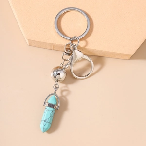 Gros plan sur un porte-clés bohème en turquoise hexagonale avec fermoir en métal