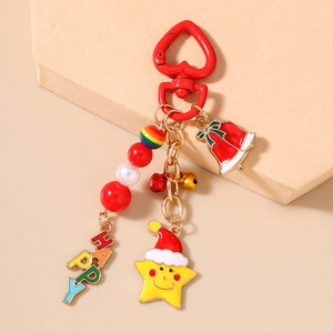 Detail showing the Christmas bell, star, and 'HAPPY' beads on a red heart keychain