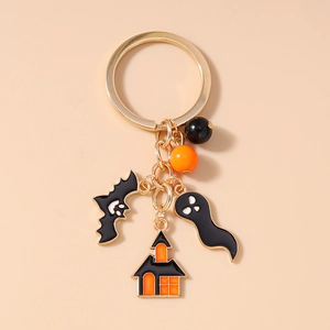 Detail of Halloween keychain featuring bats, ghosts and castles with gold finish
